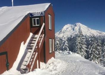 Ski hit with snow on roof overlooking Mt. Rainier on a clear day