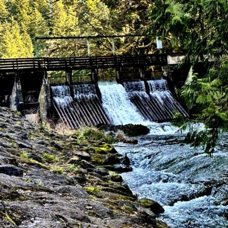 wooden bridge spillway on creek waters flowing