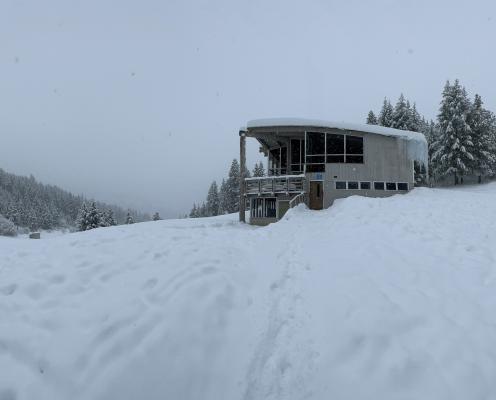 Lodge surrounded by snow and trees.