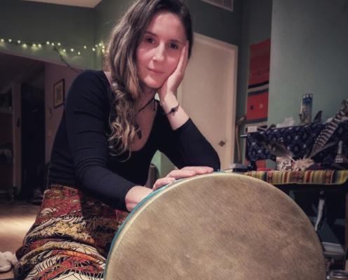 A drum placed in front of Musician Emily Deason cropped