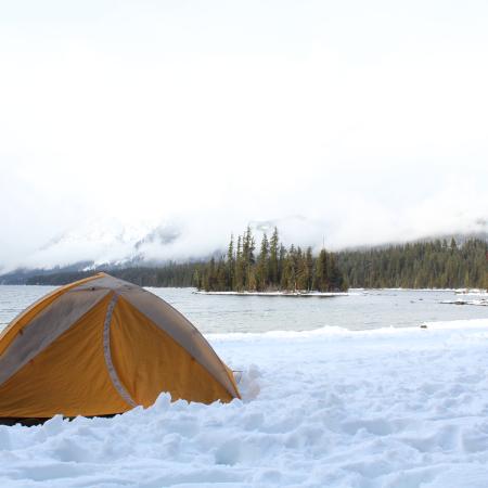 Orange tent in front of Lake Wenatchee in the snow and ice