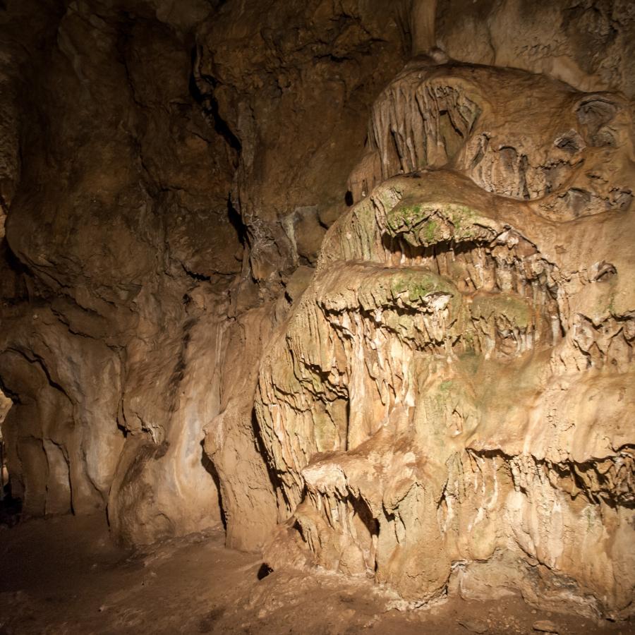 A large geologic feature is lit with a metal pathway in the background.