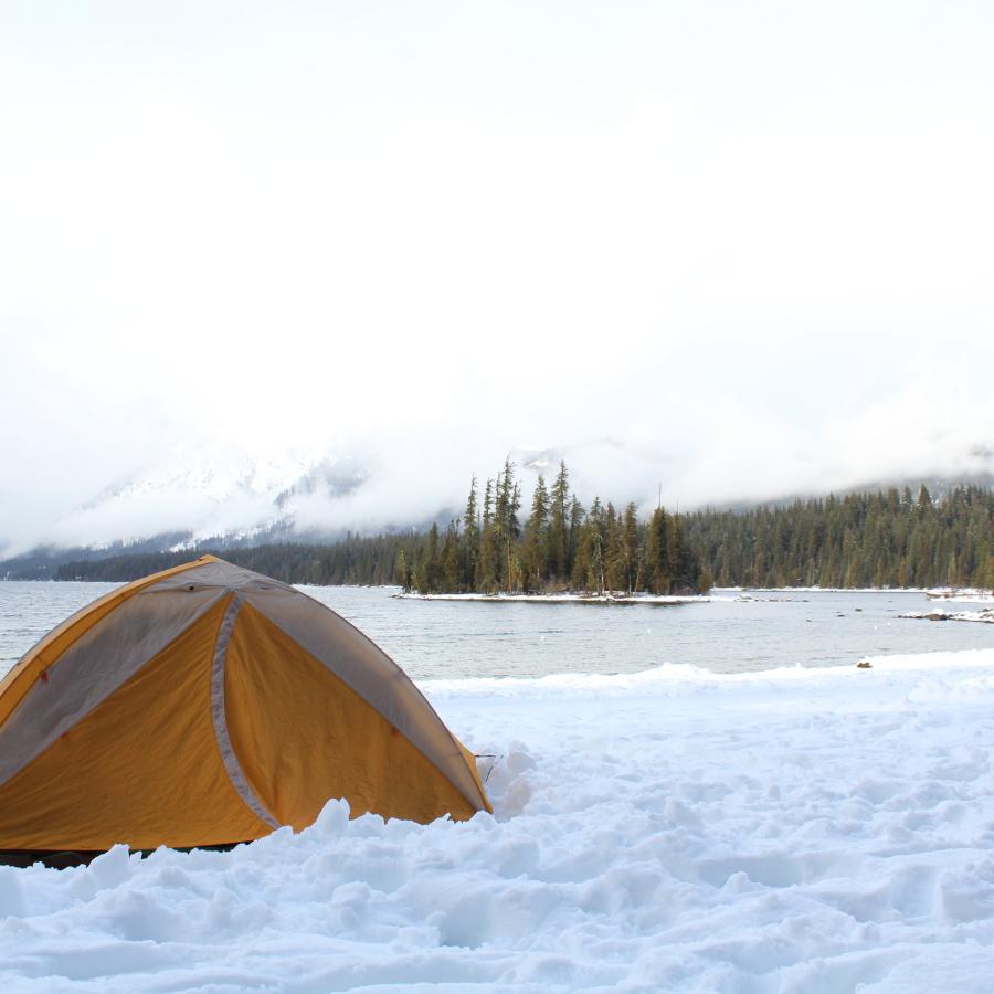 Orange tent in front of Lake Wenatchee in the snow and ice