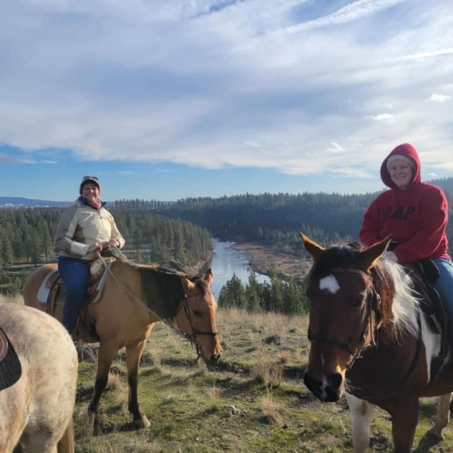 Horses and riders with a view of the Spokane River