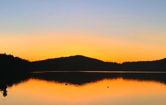 Sunset on lake water with mountains 